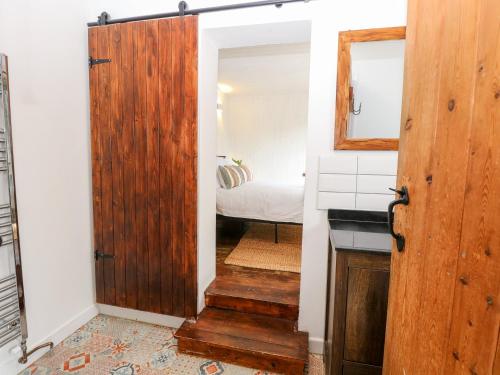 eine Tür, die in ein Schlafzimmer mit einem Bett führt in der Unterkunft Vintner's Cottage in Norwich
