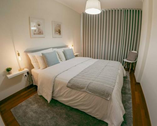 una camera da letto con un grande letto bianco con cuscini blu di Kora Home a Santa Cruz