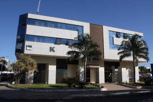 a building with palm trees in front of it at Flat Noroeste Square by CentoEdez in Brasilia