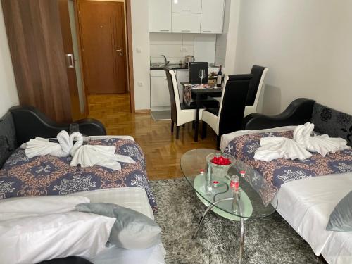 ein Hotelzimmer mit 2 Betten und einem Tisch in der Unterkunft Lavanda san - Vrnjačka Banja in Vrnjačka Banja