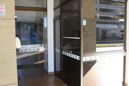 two glass doors in a building with a truck in it at Flat Noroeste Square by CentoEdez in Brasilia