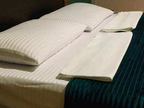 a bed with white sheets and pillows on it at Apartment Mari in Kutaisi