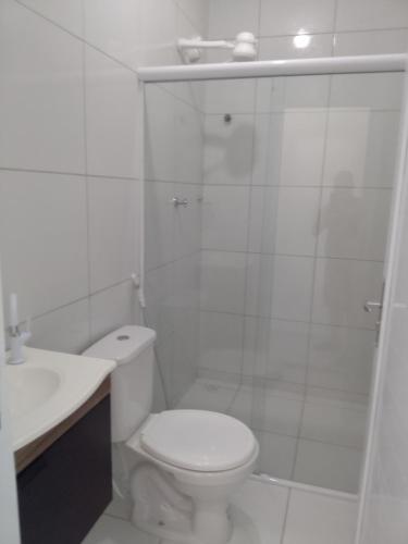 a white bathroom with a toilet and a shower at Sol Apartamento 4 - Quarto e sala com varanda e cozinha americana na praia do prea-CE in Prea
