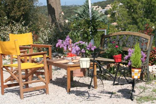 2 Stühle und ein Tisch mit Blumen drauf in der Unterkunft LA BERGERIE PROVENCALE in Ginasservis