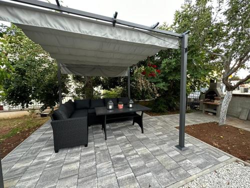a patio with a couch and a table under a canopy at Apartments Erenda in Fuškulin