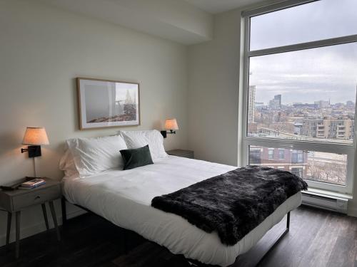 a bedroom with a large bed and a large window at Flexhome River West Studio N5 with Gym and Rooftop - READ INFO in Chicago