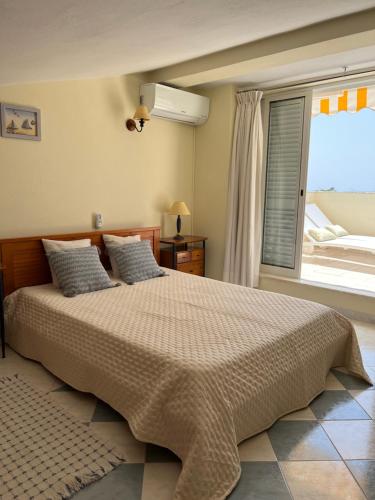 una camera con un grande letto e una finestra di Vilas do Mar - Studio a Carvoeiro