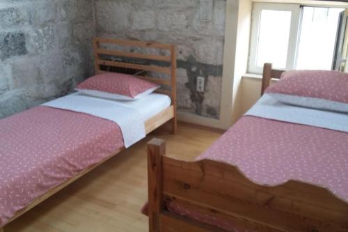 2 camas en una habitación con sábanas rosas y blancas en Korčula Sunset apartman en Korčula