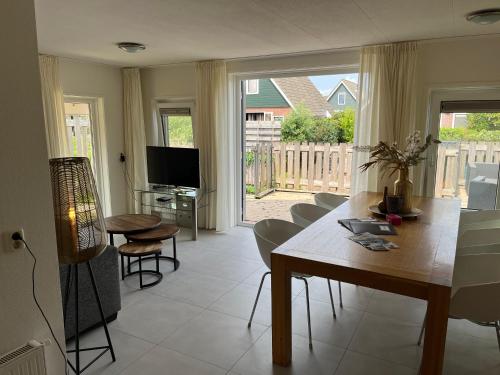 a living room with a table and chairs and a television at Bello in Opperdoes