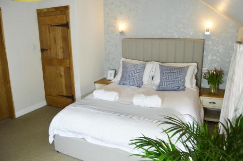 a bedroom with a bed with blue and white pillows at Goyt Cottage in Stockport