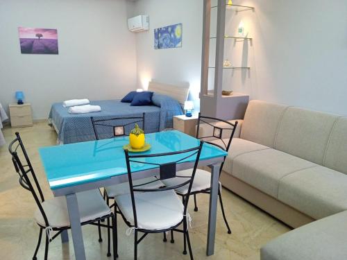 sala de estar con mesa azul y sofá en Bougainvillea casa vacanza, en Castelbuono