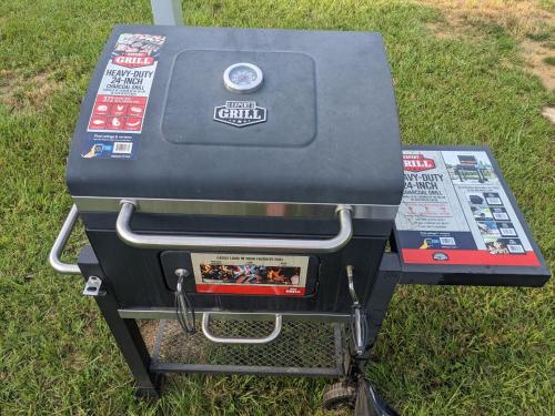 a gas grill sitting on the grass in the grass at Chigger Hill RV Park in Hatfield