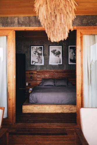 a bed in a room with pictures on the wall at Naked Hotel Zipolite -Adults Only- in Zipolite