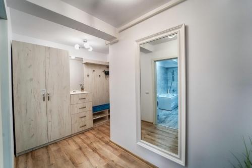 a bathroom with a large mirror and a sink at Apartament Bacovia in Bacău