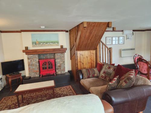 a living room with a couch and a fireplace at The Old School Caeathro, Snowdon, Eryri and Yr Wydffa Cottages in Caernarfon