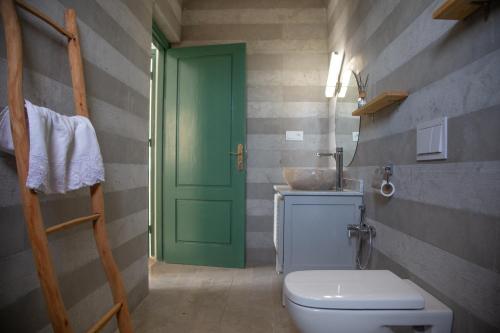 ein Badezimmer mit einem WC und einer grünen Tür in der Unterkunft WINK house : Charme et Sérénité in Essaouira