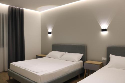 um quarto com duas camas e duas luzes em David's Studio Stays em Vlorë
