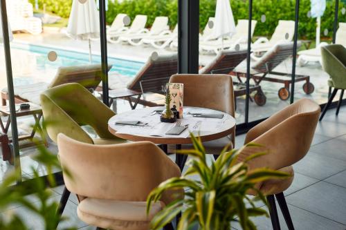 a table and chairs in a restaurant with a pool at Arancini Residence in Vodice