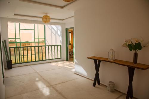 a room with a table and a balcony at WINK house : Charme et Sérénité in Essaouira