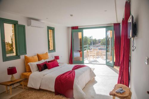 a bedroom with a large bed and a balcony at WINK house : Charme et Sérénité in Essaouira