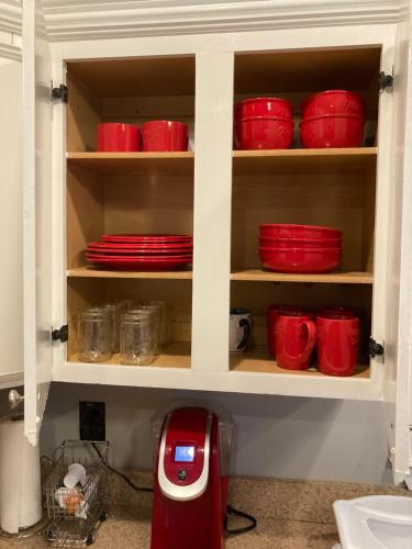 een keukenkast met rode borden en een rode blender bij Warm & Spacious 3bdr HOME in Historic Port Norfolk in Portsmouth
