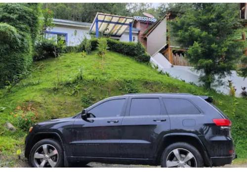a black suv parked in front of a house at Chalet los Pinos Constanza in Arroyo Frío