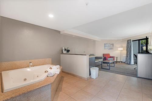 a bathroom with a bath tub and a living room at Best Western Plus Wine Country Inn & Suites in Santa Rosa