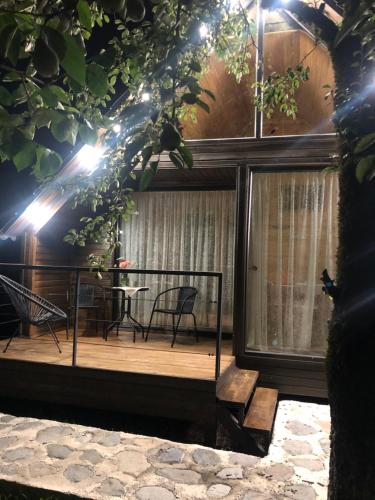 a house with a deck with a table and chairs at WOOD HOUSE LAGODEKHI in Lagodekhi