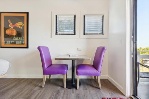 a dining room with purple chairs and a table at Hotel Folly with Marsh and Sunset Views in Folly Beach