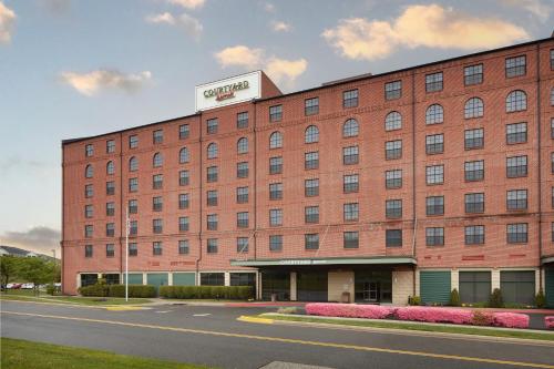 un gran edificio de ladrillo rojo con un cartel. en Courtyard Aberdeen at Ripken Stadium en Aberdeen