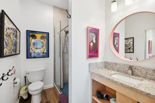 a bathroom with a toilet and a sink and a mirror at Hotel Folly with Marsh and Sunset Views in Folly Beach