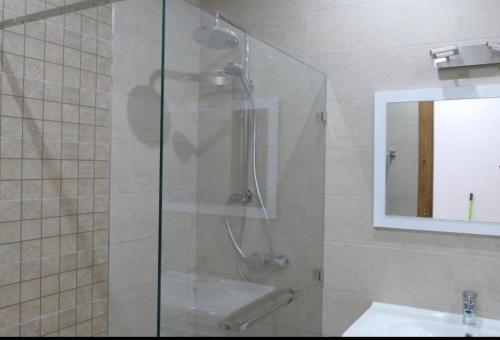 a glass shower in a bathroom with a sink at Villa Shams - with Pool in Mellita