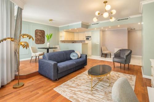 a living room with a blue couch and chairs at Queen's Court Hotel & Residence in Budapest