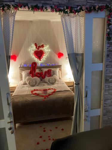 ein Schlafzimmer mit einem Bett mit einem Liebesschild drauf in der Unterkunft Sweet home, logement de tourisme in Étaples