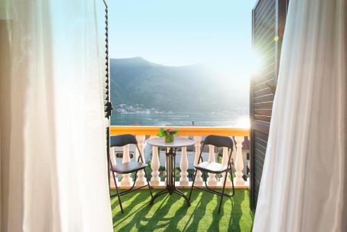 a balcony with chairs and a table with a view of the ocean at Apartment Ena with amazing sea view in Kotor