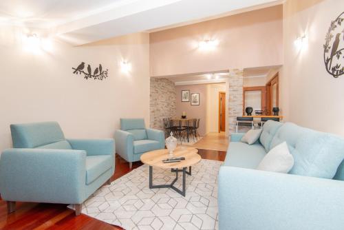 a living room with blue chairs and a table at Apartment Ena with amazing sea view in Kotor