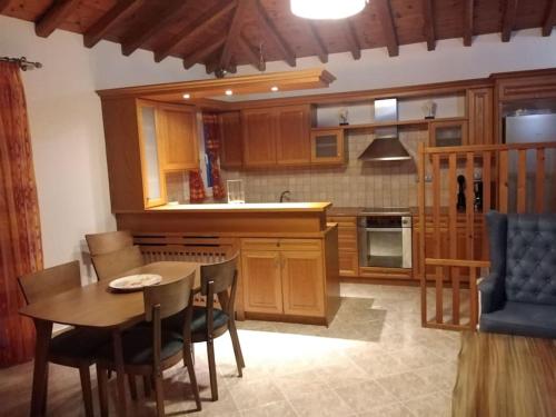 eine Küche mit Holzschränken sowie einem Tisch und Stühlen in der Unterkunft Like my house in Skiathos-Stadt