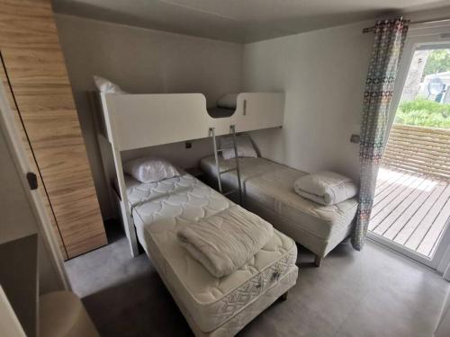 une chambre avec deux lits superposés et une fenêtre dans l'établissement Location mobil-home Camping les Sables d'Or 4 étoiles, Cap d'Agde, au Cap d'Agde