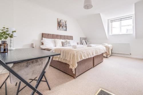 a white bedroom with a bed and a table at Large 4 Bed Ideal for Contractors - Free Parking in Bedford
