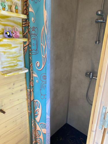 La salle de bains est pourvue d'une douche avec rideau de douche. dans l'établissement Roulotte pour une nuit en amoureux tout équipée.., à Noyelles-sur-Mer