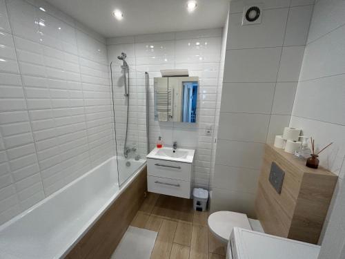 een badkamer met een bad, een wastafel en een toilet bij Sobola Apartment in Suwałki
