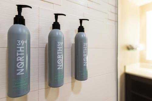 three bottles of shampoo on a wall in a bathroom at Residence Inn Denver Cherry Creek in Denver