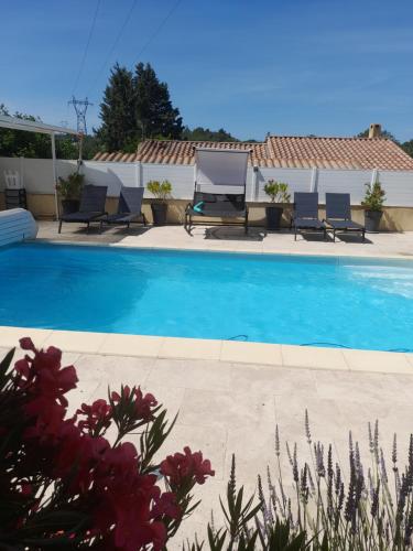 a swimming pool with chairs and a house at Studio sympa meublé avec parking privé et piscine in Manosque