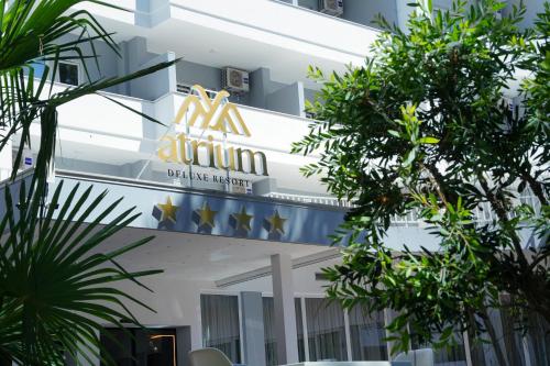 Atrium Deluxe Resort في غوليم: علامة على واجهة مبنى به اشجار