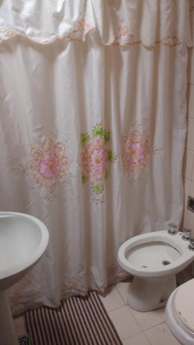 baño con aseo y cortina de ducha con flores en deolinda en Mendoza