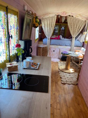 une chambre avec une table et une chambre avec un lit dans l'établissement Roulotte pour une nuit en amoureux tout équipée.., à Noyelles-sur-Mer