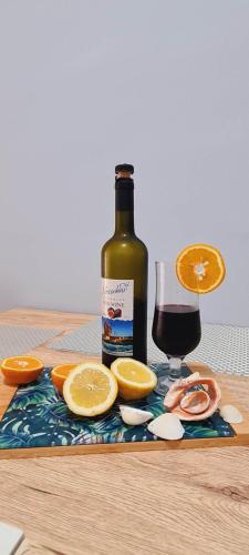 a bottle of wine and a glass of orange slices at Apartament Sorrento in Marina Cape in Aheloy