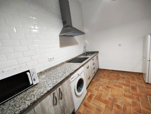 uma cozinha com um fogão, um lavatório e uma máquina de lavar roupa em Casa SANTA MARÍA em Carmona