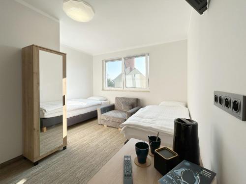 1 dormitorio con espejo, 1 cama y 1 silla en Mandarin Jarosławiec, en Jarosławiec