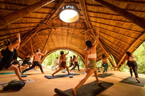 een groep mensen die yoga doen in een gebouw bij SelvaMinca in Minca